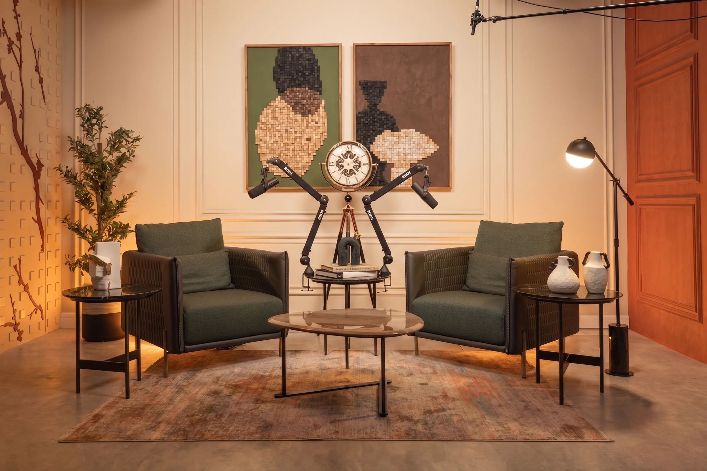 Aura studio at Legato Studio: green armchairs, podcast mic arms and wooden mosaic artworks on a panelled cream wall