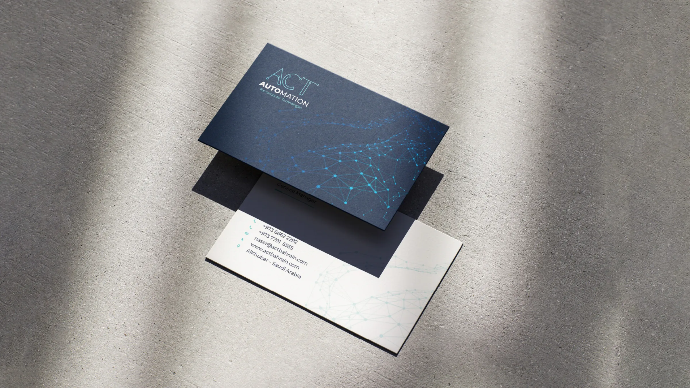 ACT Automation business cards with a navy circuit-pattern design on a concrete surface