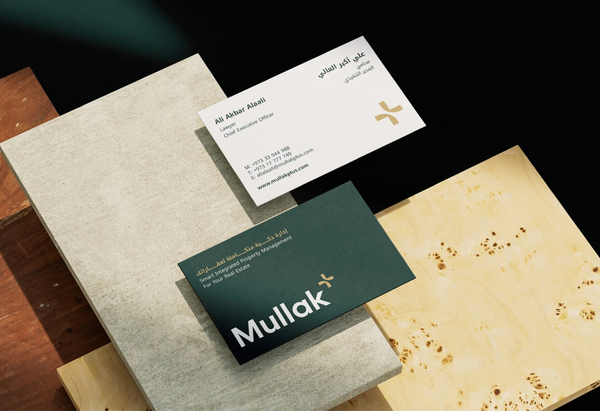 Mullak+ business cards in teal and white on stone and burl-wood surfaces