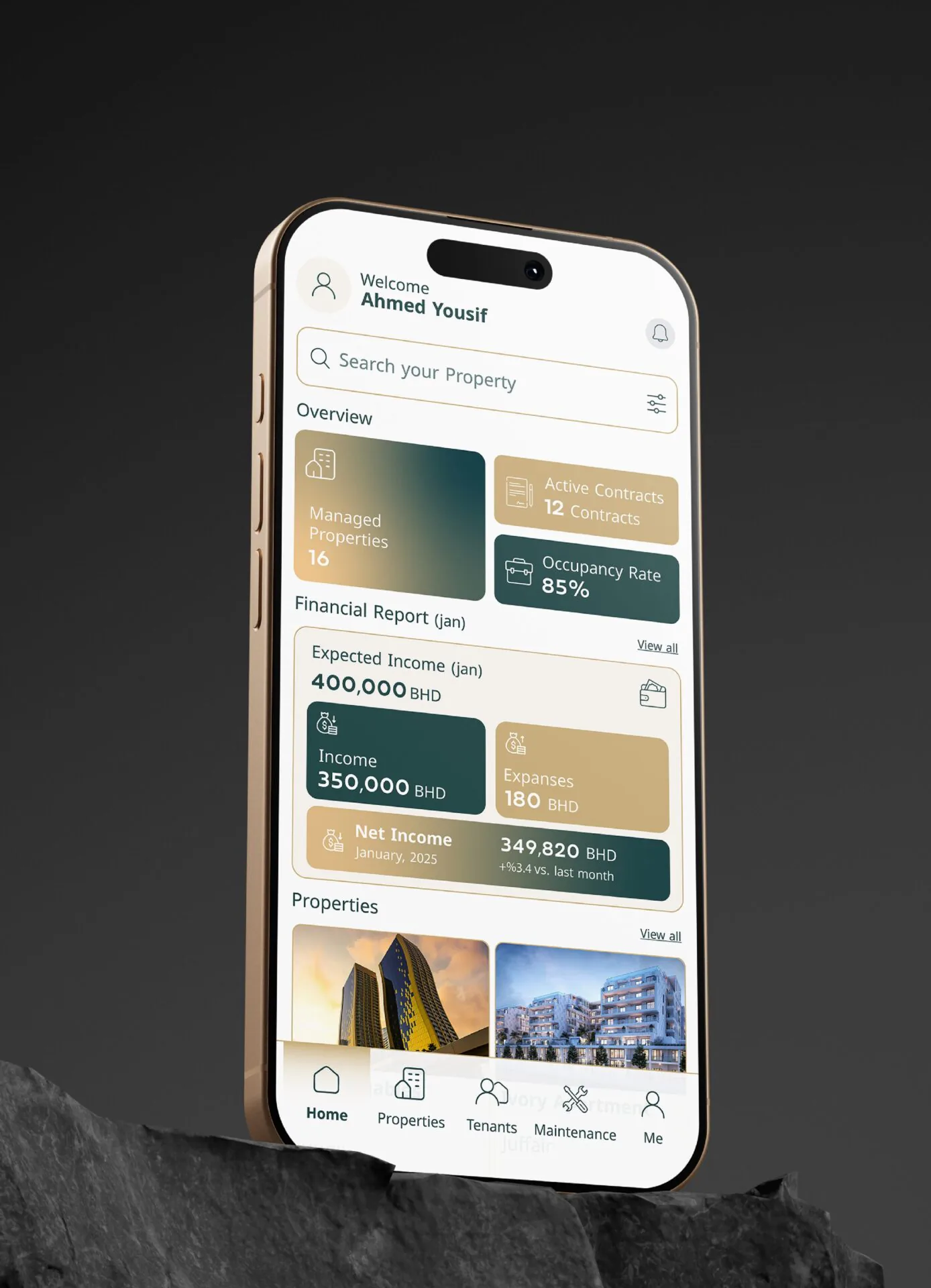 Gold iPhone on a dark rock showing the Mullak+ dashboard with financial summaries