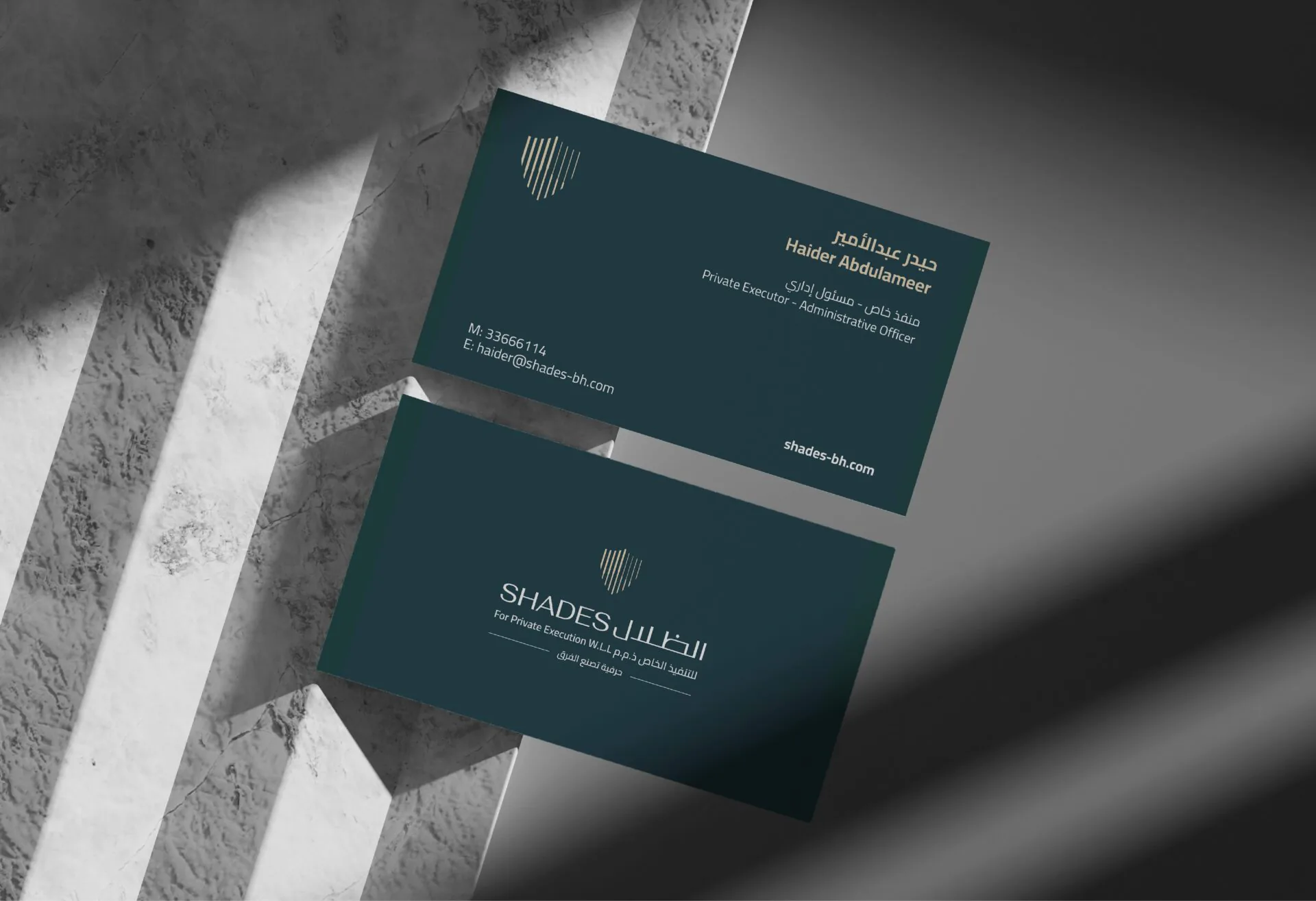Charcoal blue Shades Bailiff business cards on grey concrete steps with hard shadows
